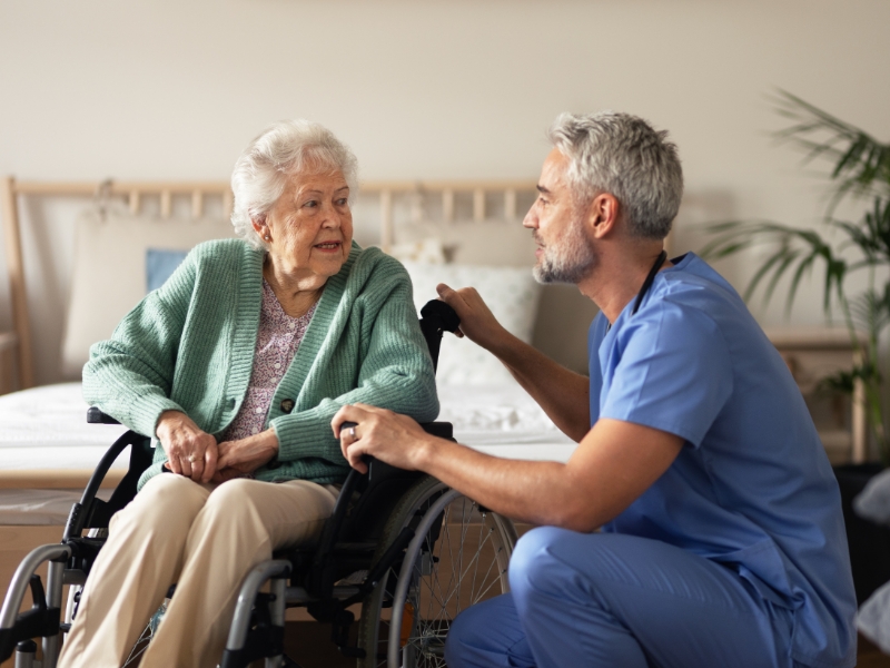Male nurse caregiving for elderly woman.