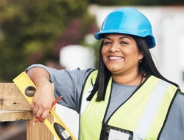 Female construction worker smiling on site.