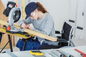 young woman in wheelchair using a saw